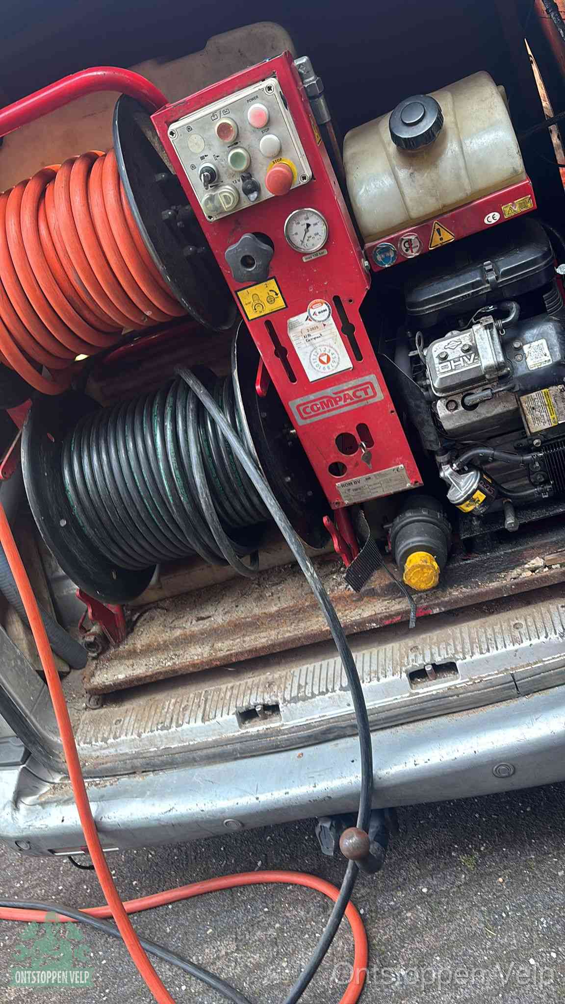 Een rood hogedruk-rioolreinigingstoestel in de laadbak van de bedrijfsbus, apparatuur voor een hardnekkige afvoerverstopping in Velp