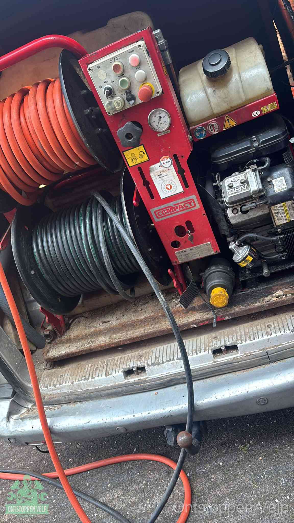 Een rood hogedruk-rioolreinigingstoestel met slangen in de laadbak van de bedrijfsbus, apparatuur voor een hardnekkige wc-verstopping in Velp