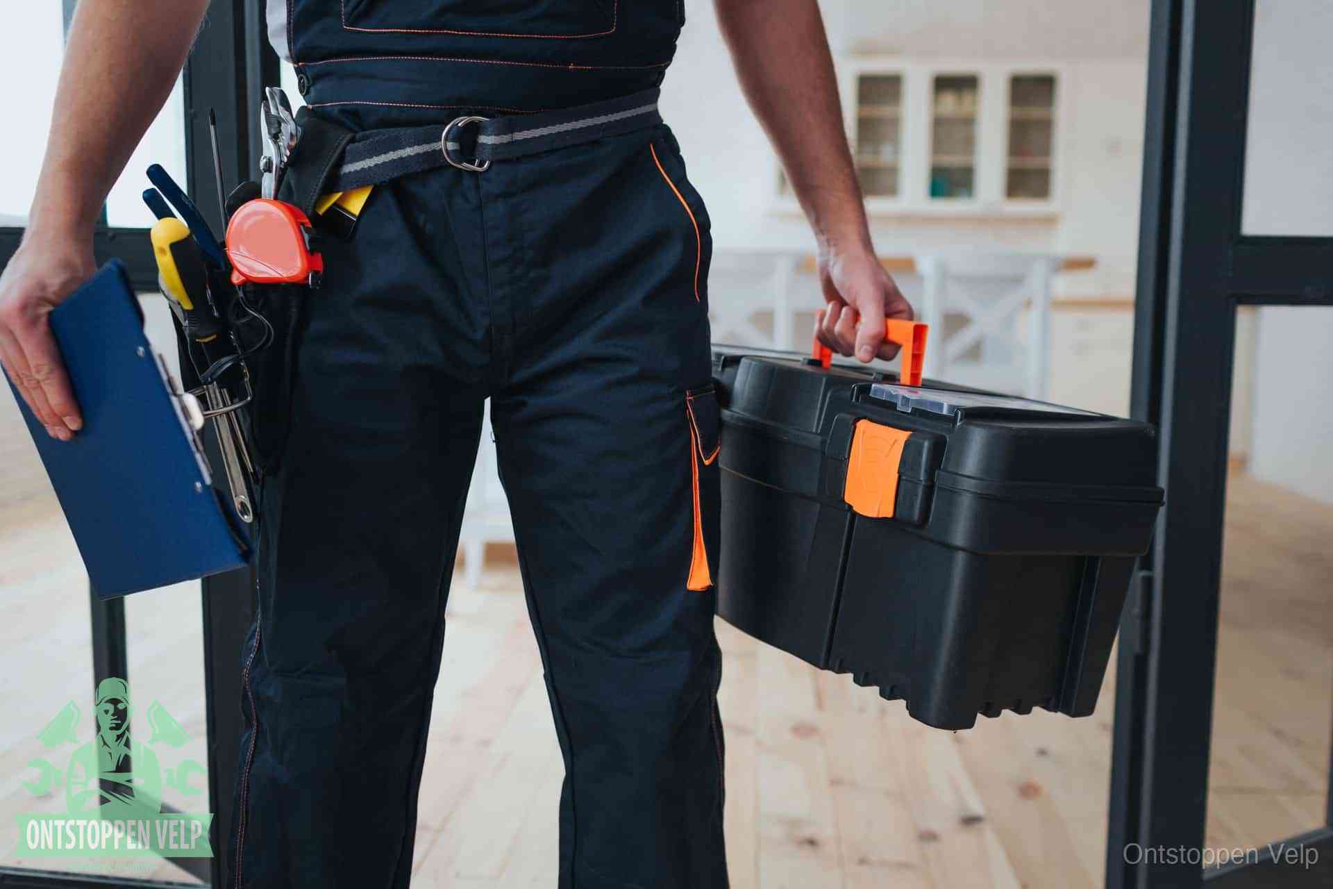 Een monteur met gereedschapsriem en klembord in een keuken, klaar om een transparante prijs voor het gootsteen ontstoppen in Velp te geven