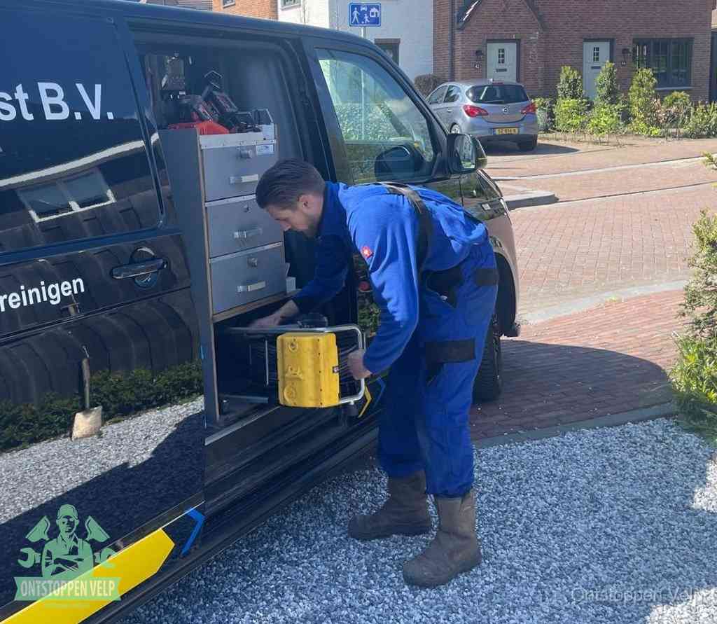 Een monteur pakt apparatuur uit de bedrijfsbus voor service aan huis, het moment om een professional in te schakelen in Velp